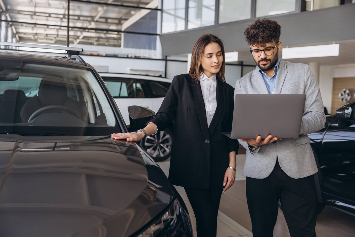 Salesman demonstrating a car to a customer